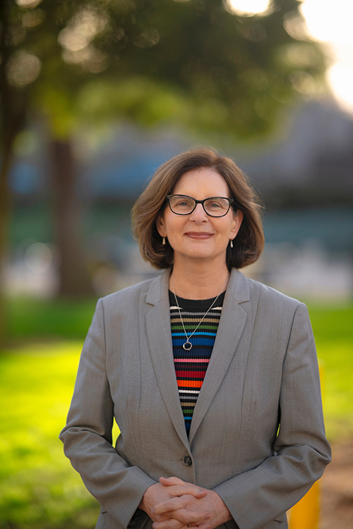 Dean Carol Padden in rainbow striped shirt and grey blazer